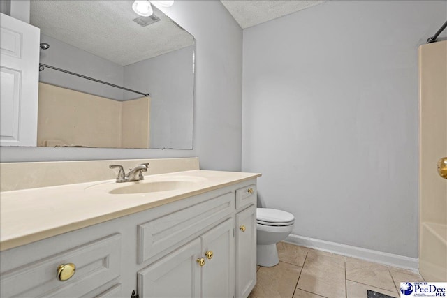 bathroom with tile patterned flooring, vanity, a textured ceiling, and toilet