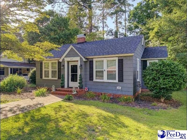 1417 Woods Rd, Florence, SC 29501 - bungalow-style house with a front lawn, a shingled roof, and a chimney