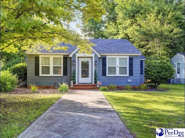 1417 Woods Rd, Florence, SC 29501 - bungalow-style house featuring a front lawn and roof with shingles