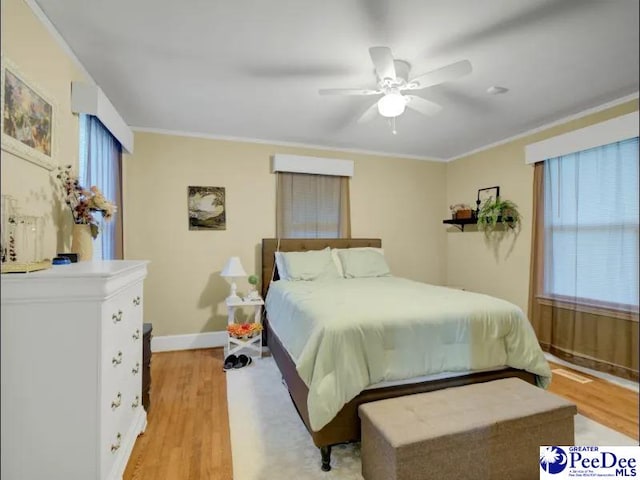 1417 Woods Rd, Florence, SC 29501 - bedroom with light wood-type flooring, multiple windows, ornamental molding, and a ceiling fan