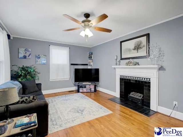 1417 Woods Rd, Florence, SC 29501 - living room with ornamental molding, a ceiling fan, a tile fireplace, and wood finished floors