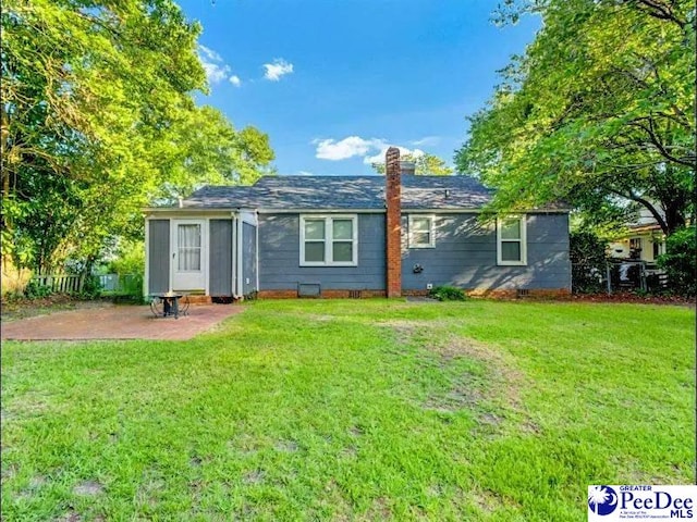 1417 Woods Rd, Florence, SC 29501 - back of house featuring a patio, a lawn, and a chimney