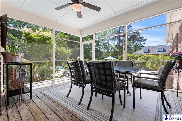 sunroom / solarium with a ceiling fan, plenty of natural light, and outdoor dining space