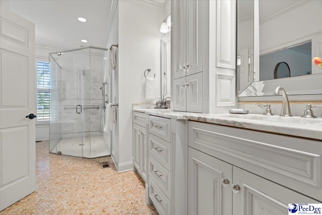 full bath with double vanity, ornamental molding, and a stall shower