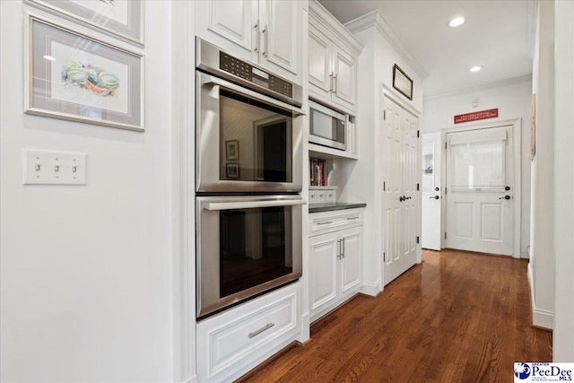 kitchen with crown molding, dark wood-style floors, recessed lighting, white cabinets, and stainless steel appliances