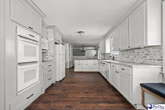 3712 E Hoyt St, Florence, SC 29506 - kitchen featuring white appliances, a peninsula, backsplash, white cabinets, and dark wood-style flooring