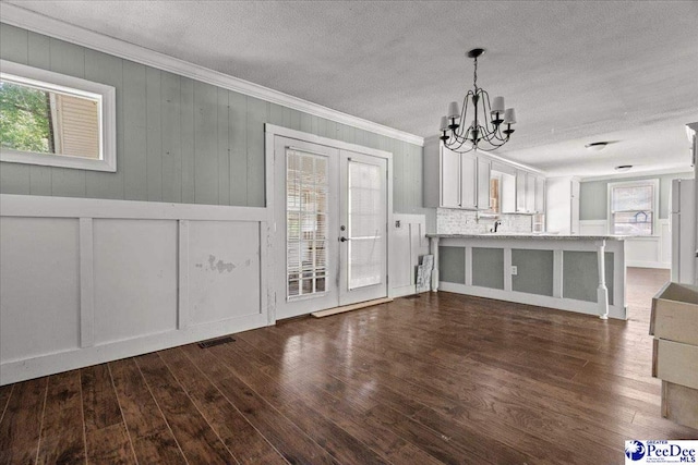 3712 E Hoyt St, Florence, SC 29506 - unfurnished dining area featuring ornamental molding, plenty of natural light, a chandelier, dark wood-style flooring, and a textured ceiling