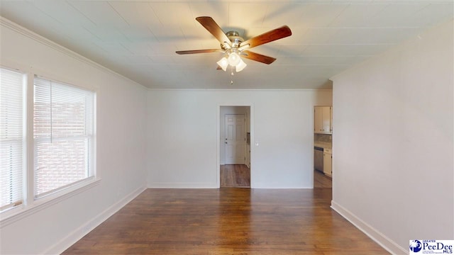 spare room featuring crown molding, dark wood-type flooring, and ceiling fan