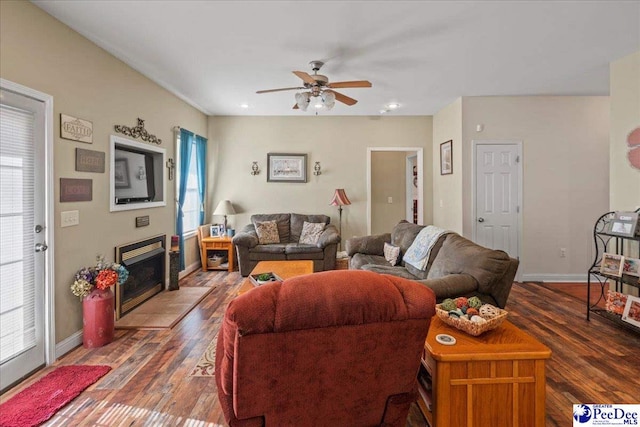 living room with ceiling fan and dark hardwood / wood-style flooring