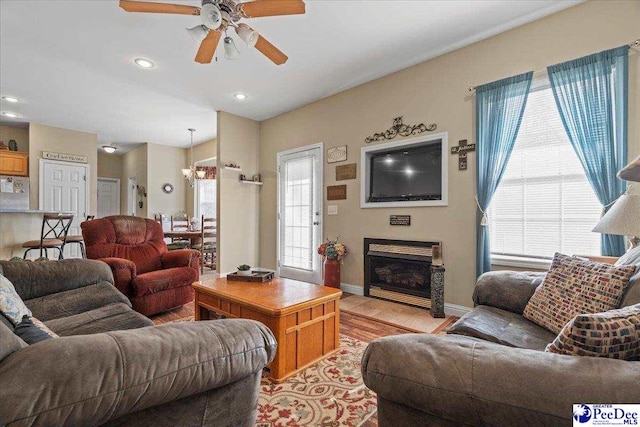 living room featuring ceiling fan, plenty of natural light, and light wood-type flooring