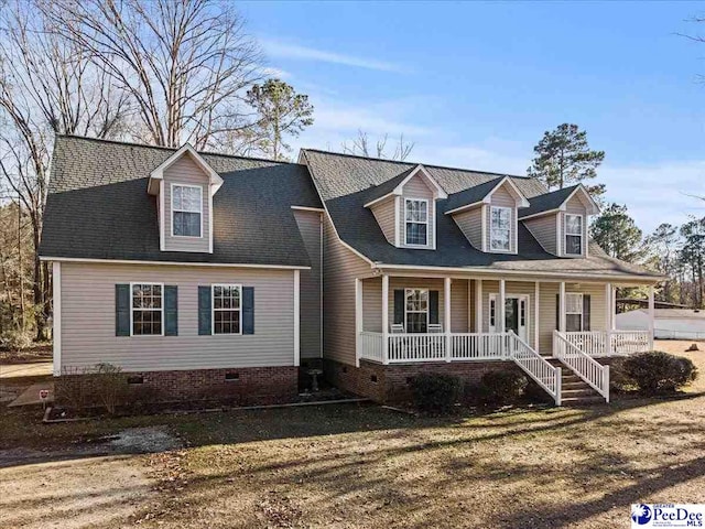 cape cod home featuring a porch and a front yard