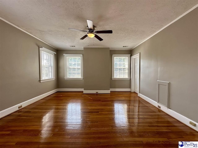 empty room with ceiling fan, ornamental molding, dark hardwood / wood-style flooring, and a textured ceiling