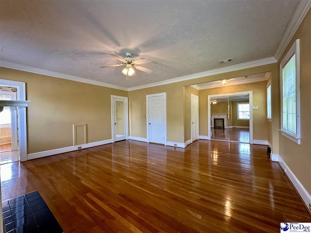 unfurnished living room with ceiling fan, ornamental molding, dark hardwood / wood-style floors, and a textured ceiling