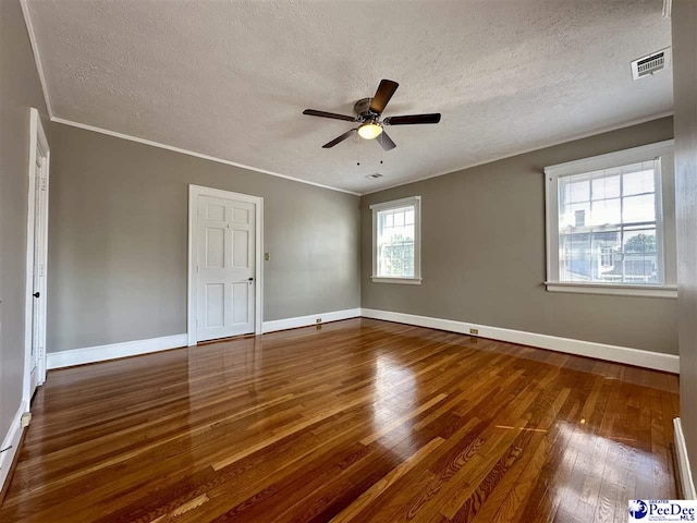 unfurnished room with ornamental molding, dark wood-type flooring, a textured ceiling, and ceiling fan