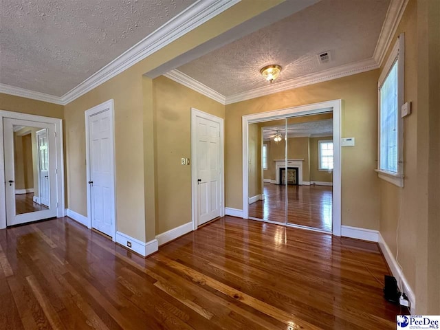 interior space featuring hardwood / wood-style flooring, crown molding, and a textured ceiling