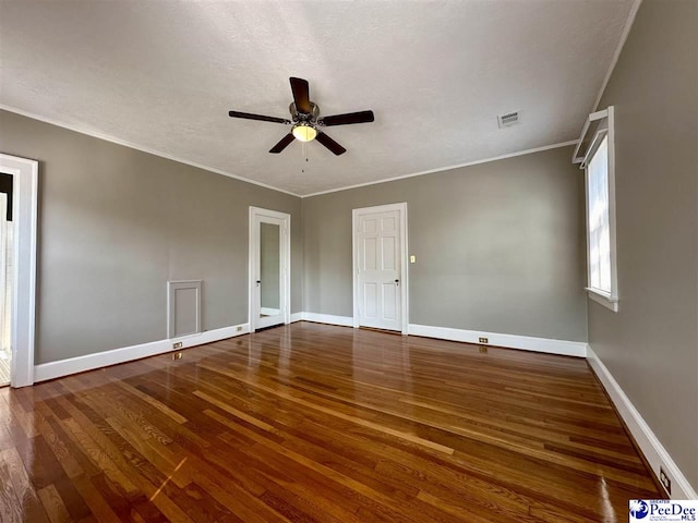 unfurnished room with a textured ceiling, dark wood-type flooring, ornamental molding, and ceiling fan