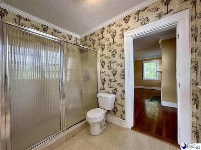 bathroom featuring crown molding, an enclosed shower, a textured ceiling, tile patterned floors, and toilet