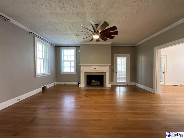 unfurnished living room with hardwood / wood-style flooring, ornamental molding, ceiling fan, and a textured ceiling