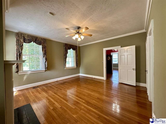 empty room featuring hardwood / wood-style flooring, ceiling fan, crown molding, and a textured ceiling