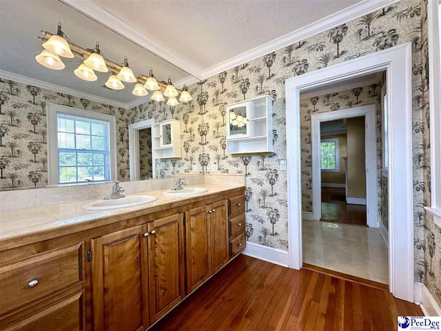 bathroom with vanity, crown molding, wood-type flooring, and a textured ceiling