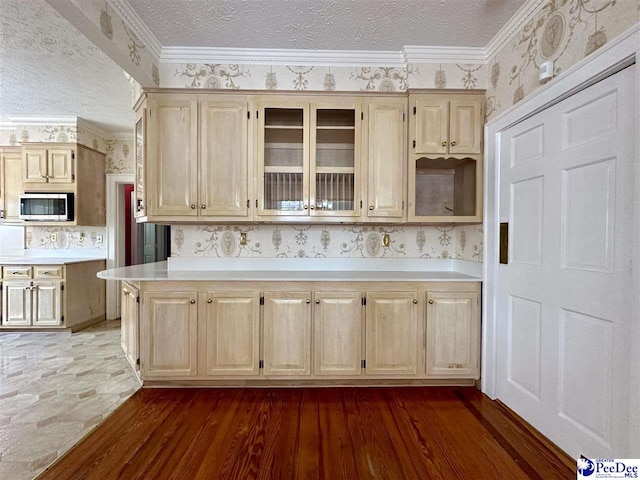 kitchen featuring crown molding, dark hardwood / wood-style floors, and a textured ceiling