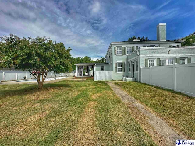 rear view of property featuring a lawn