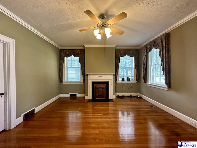 unfurnished living room with wood-type flooring, plenty of natural light, a textured ceiling, and crown molding