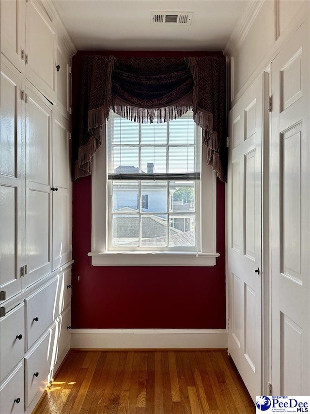 interior space with crown molding and light wood-type flooring