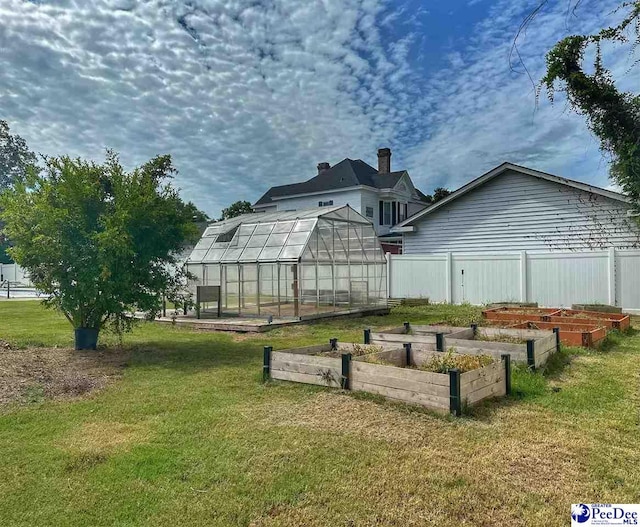 rear view of property with a yard and an outdoor structure