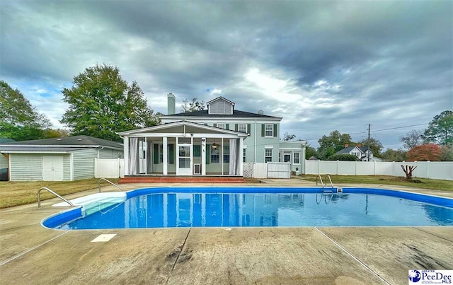 view of pool featuring a storage shed and a patio area