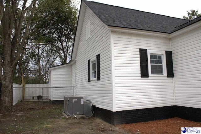 114 Law St, Darlington, SC 29532 - view of home's exterior with central AC, roof with shingles, and fence