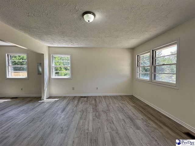 unfurnished room featuring hardwood / wood-style flooring and a textured ceiling