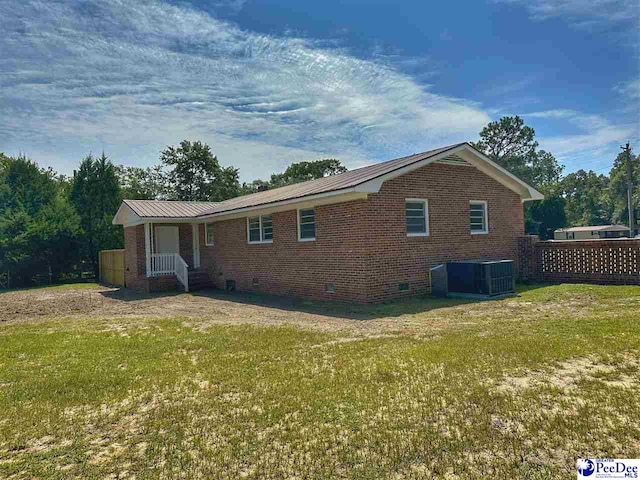 exterior space with central AC and a yard