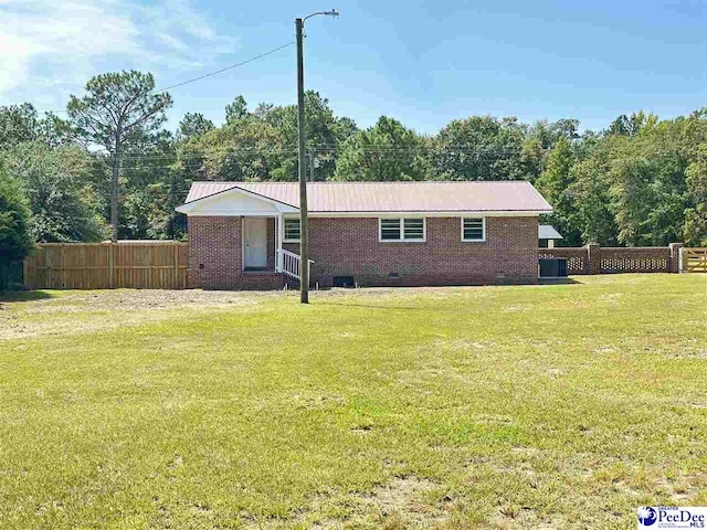 back of property with central air condition unit and a lawn