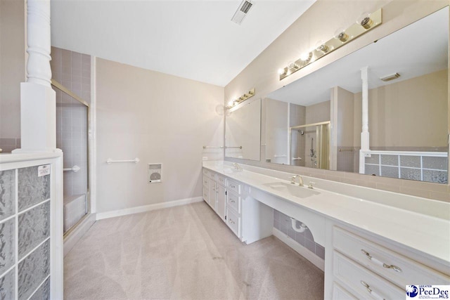 bathroom with vanity and a shower with door