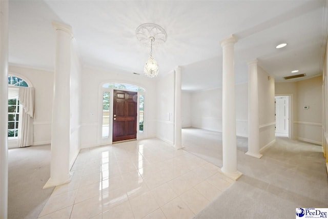 entrance foyer featuring decorative columns, light tile patterned flooring, and crown molding