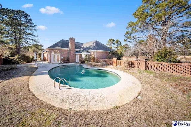 view of swimming pool with french doors and a patio area