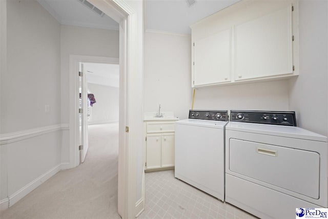 laundry area with sink, cabinets, ornamental molding, washing machine and clothes dryer, and light carpet