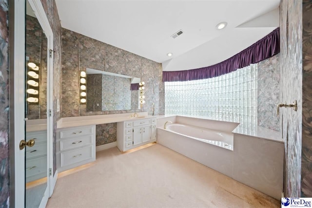 bathroom featuring a washtub, vanity, and vaulted ceiling