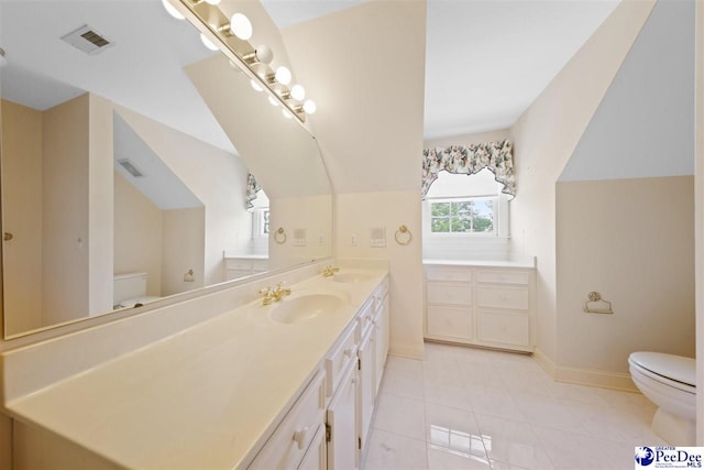 bathroom featuring tile patterned floors, vanity, toilet, and vaulted ceiling