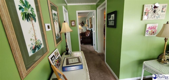 corridor featuring carpet, baseboards, and crown molding