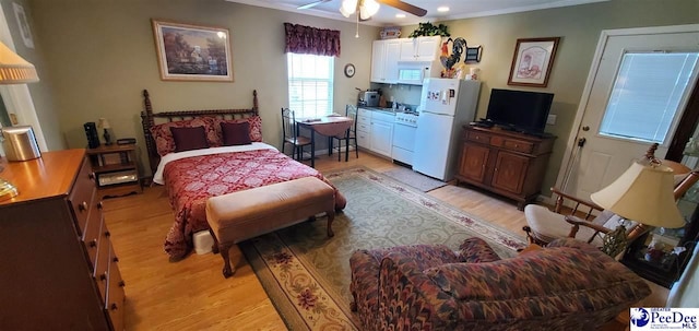 bedroom featuring ceiling fan, ornamental molding, light wood-type flooring, and freestanding refrigerator