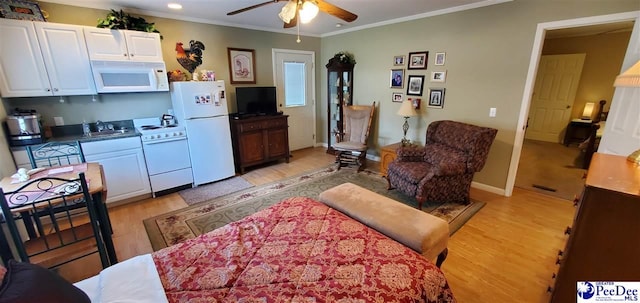 living room with ornamental molding, light wood-type flooring, ceiling fan, and baseboards