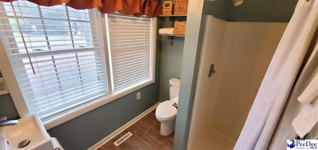 full bath featuring curtained shower, wood finish floors, and visible vents