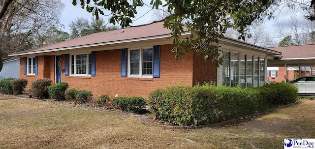 view of home's exterior with a carport and brick siding