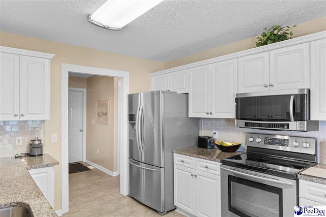2122 Twin Bridge Dr, Florence, SC 29505 - kitchen featuring appliances with stainless steel finishes, white cabinets, tasteful backsplash, a textured ceiling, and light stone countertops