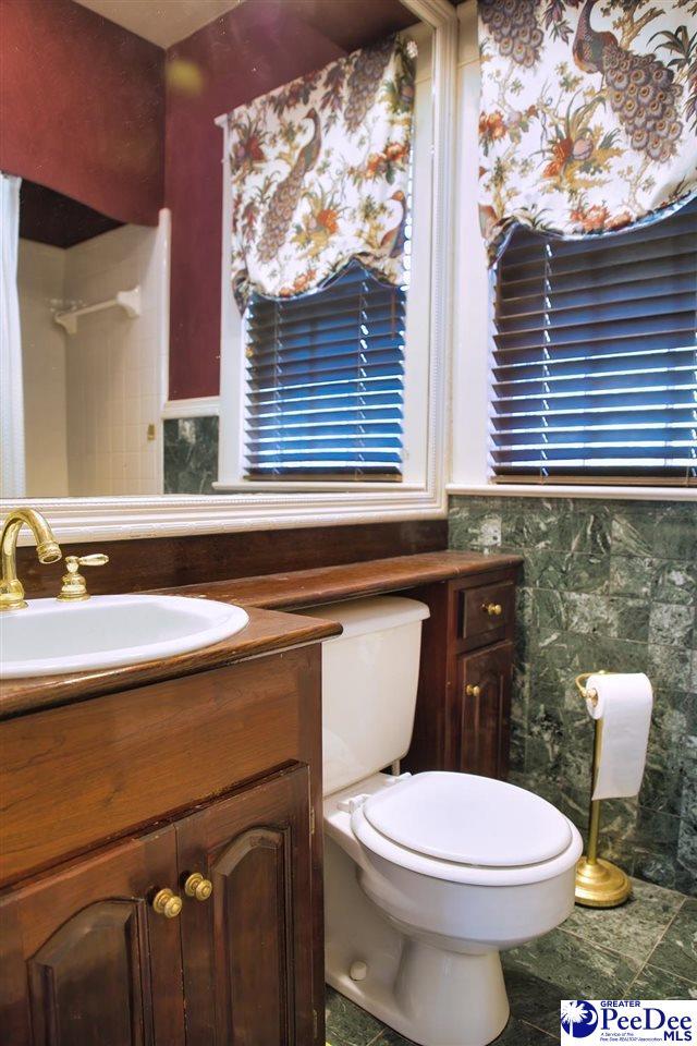 bathroom featuring tile walls, vanity, and toilet