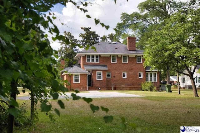 back of house with a yard and a patio