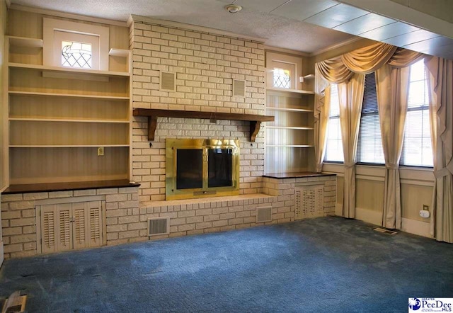 unfurnished living room with carpet, a wealth of natural light, a fireplace, and a textured ceiling