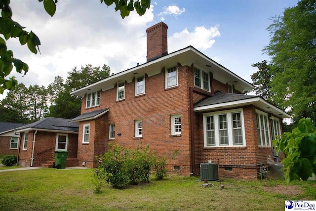 back of house with cooling unit and a yard